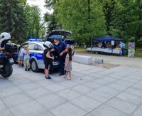 policjant z dziećmi stoja przy radiowozie