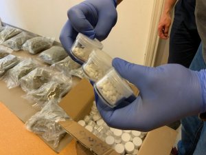 policjant trzyma woreczek z zabezpieczonymi narkotykami