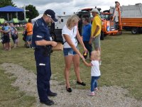 policjant rozdaje odblaski obok matka z dzieckiem