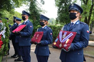 Policjanci w trakcie trwania uroczystości pogrzebowych trzymają odznaczenia państwowe