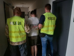 dwaj policjanci z zatrzymanym mężczyzną