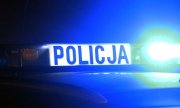 Napis Policja na dachu na belce policyjnego radiowozu, obok z prawej strony widoczna świecąca na niebiesko lampa radiowozu