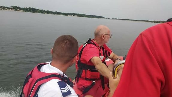 Policjant wspólnie z ratownikami WOPR patrolujący tereny wodne.