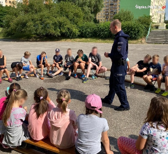 Policjant stojący pomiędzy dziećmi.