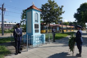 Zastępca Komendanta Głównego Policji nadinsp. Paweł Dobrodziej w asyście warty honorowej składa wiązankę kwiatów pod pamiątkowa tablica poświęconą tragicznie zmarłemu policjantowi Andrzejowi Strujowi