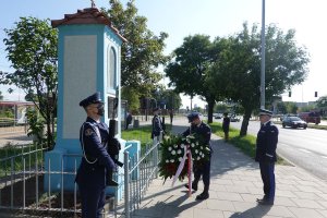 Zastępca Komendanta Głównego Policji nadinsp. Paweł Dobrodziej w asyście warty honorowej składa wiązankę kwiatów pod pamiątkowa tablica poświęconą tragicznie zmarłemu policjantowi Andrzejowi Strujowi