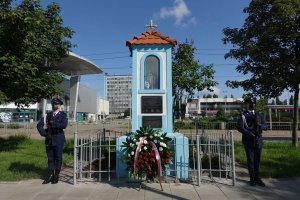 Zastępca Komendanta Głównego Policji nadinsp. Paweł Dobrodziej w asyście warty honorowej składa wiązankę kwiatów pod pamiątkowa tablica poświęconą tragicznie zmarłemu policjantowi Andrzejowi Strujowi