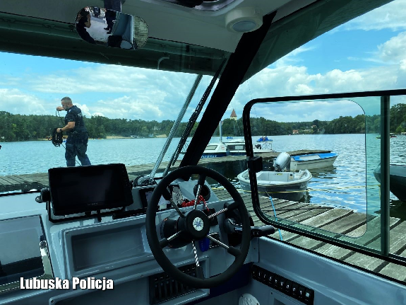 Policjant wspólnie z motorówką policyjną na wodzie.