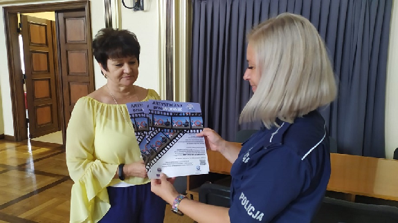 Policjantka prezentująca plakat konkursu artystyczny przewodnik.