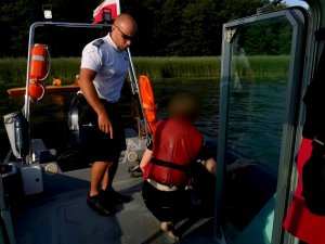 policjant i uratowana osoba na łodzi policyjnej