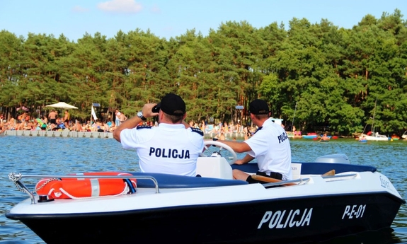 Policjanci na motorówce obserwujący plażę