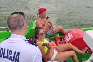 policjant rozmawia z parą na rowerze wodnym