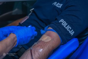 ręka policjanta pod czas oddawania krwi