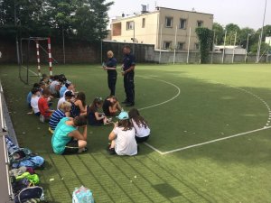 policjanci podczas lekcji plenerowej rozmawiają z dziećmi o bezpieczeństwie