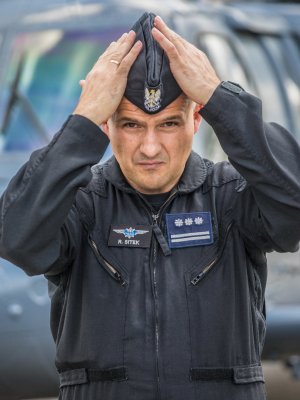 Szef lotnictwa policyjnego insp. pil. Robert Sitek na tle policyjnego Black Hawka.