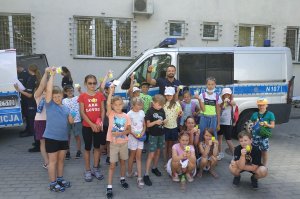 policjanci z dziećmi pozują przed komisariatem