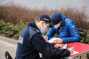 policjant i inny mężczyzna wypełniają ankiety  przed pobraniem krwi