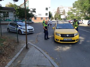 dwaj policjanci kontrolują kierowcę samochodu, obok stoi radiowóz