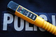 żółte urządzenie alcoblow leżące na białym napisie Policja