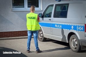 Policjant służby kryminalnej przy radiowozie