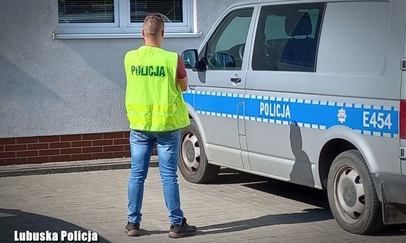 Policjant służby kryminalnej przy radiowozie