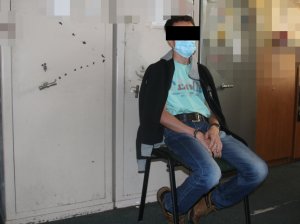 zaytrzymany mężczyzna siedzi na krześle podczas przesłuchania