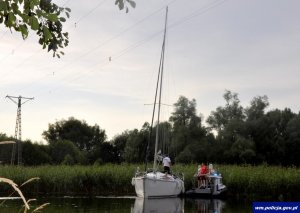 Policjanci Komendy Powiatowej Policji w Piszu na miejscu zdarzenia. Łódź żaglowa i policyjna motorówka