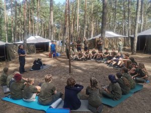 policjantka rozmawia z harcerzami wypoczywającymi na obozie