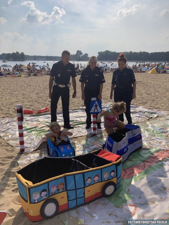 policjanci na plaży rozmawiają z dziećmi o bezpieczeństwie
