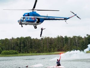 Śmigłowiec PZL Mi-2 w trakcie lotu nad zbiornikiem wodnym.