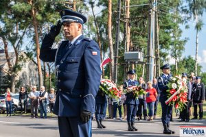 oddanie honoru przez policjanta przed tablicą upamiętniającą udział polskich policjantów w walkach z bolszewikami w 1920 r.