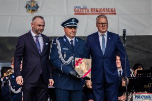 na scenie policjant z przedstawicielami władzy podczas uroczystości upamiętniającej poległych w Bitwie Warszawskiej 1920 r. policjantów