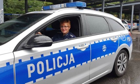 policjantka w oznakowanym radiowozie