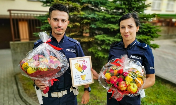 policjant i policjantka z prezentami, matka z dzieckiem na rękach, ojciec dziecka i policjant