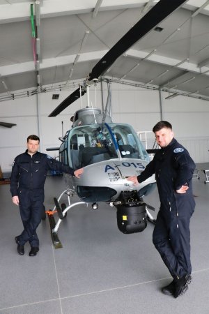 Bracia - piloci opisywani w artykule stoją przy helikopterze, którym latają w policji.