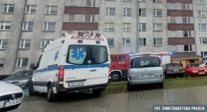 ambulans policyjnych medyków stoi przed blokiem mieszkalnym