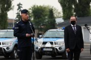 Komendant Główny Policji oraz szef MSWiA przemawiają do policjantów wyjeżdżających na Litwę na tle policyjnych pojazdów