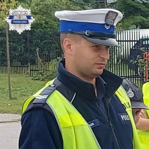 umundurowany policjant ruchu drogowego w czapce z białym otokiem na głowie i w żółtej kamizelce