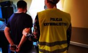 policjantka w żółtej kamizelce z napisem na plecach Policja kryminalistyka, stoi z zatrzymanym