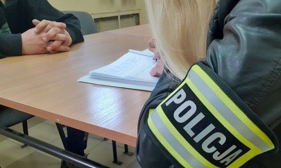 Policjantka rozmawia z zatrzymanym mężczyną