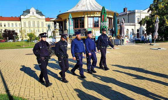 pięcioosobowy patrol umundurowanych policjantów polskich i czeskich na tle starówki&quot;