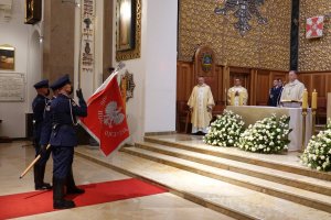 policjanci z kompani reprezentacyjnej polskiej Policji ze sztandarem z napisem Bóg, Honor, Ojczyzna stoją przed księdzem w kościele