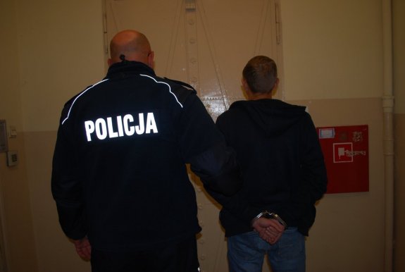 policjant stoi z zatrzymanym