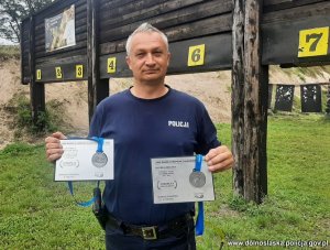 Policjant na strzelnicy z medalami.