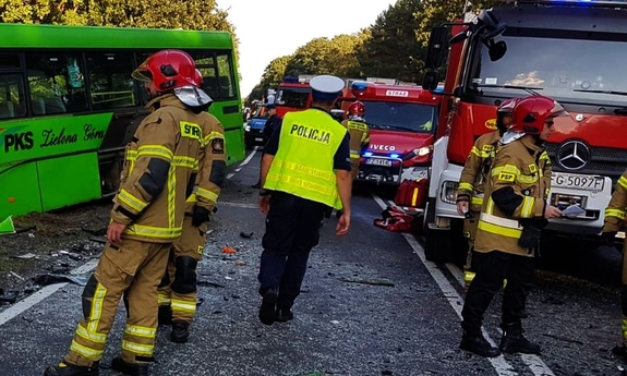 Policjant i strażacy na miejscy wypadku drogowego