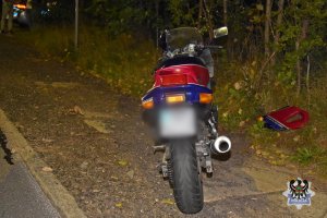 pora nocna. motocykla stojący na poboczu. Obok lezy kawałek oderwanej karoserii