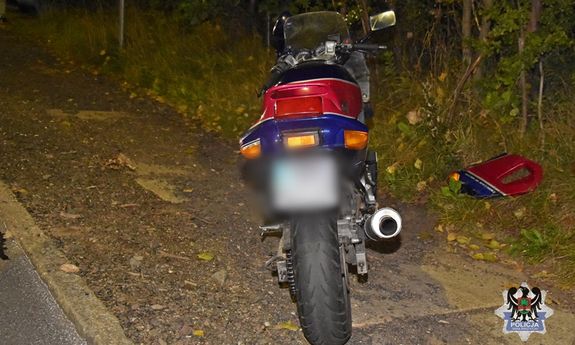 pora nocna. motocykla stojący na poboczu. Obok lezy kawałek oderwanej karoserii