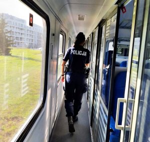 Policjantka idąca wzdłuż wagonu z przedziałami