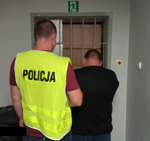 policjant z zatrzymanym mężczyzną