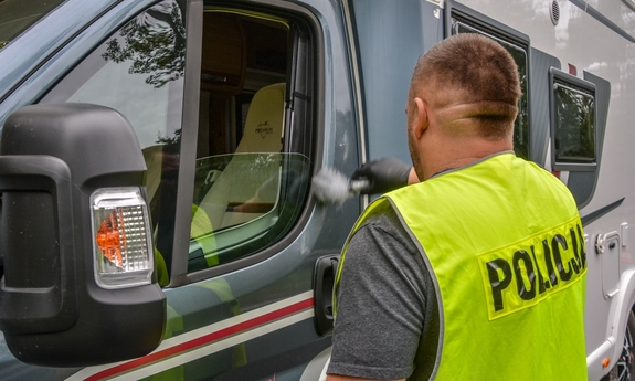 Technik kryminalistyki przeprowadzający czynność zabezpieczania śladów w odzyskanym kamperze